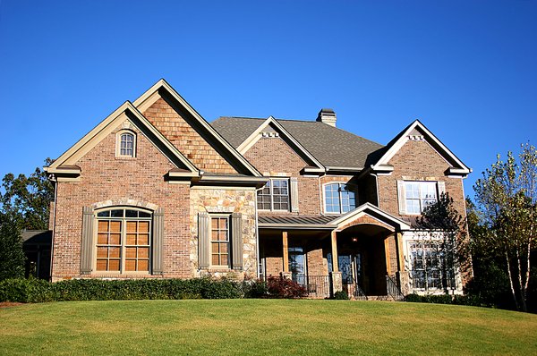 Beautiful brick front home with green lawn in the front.